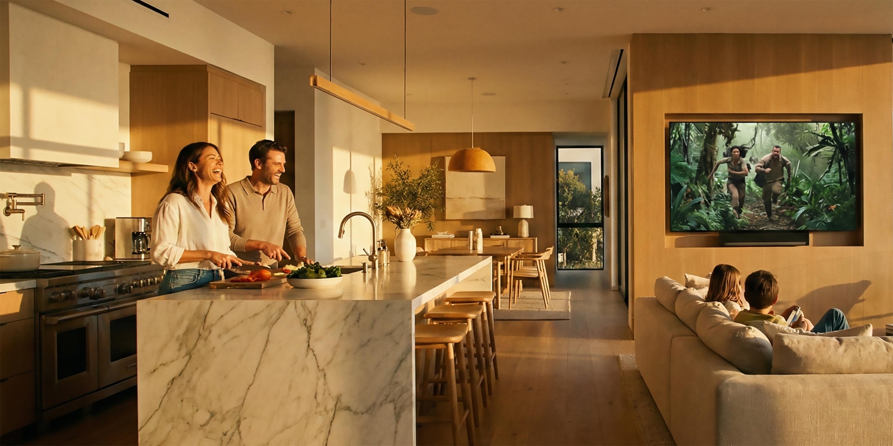 Parents cooking in modern kitchen while kids watch TV